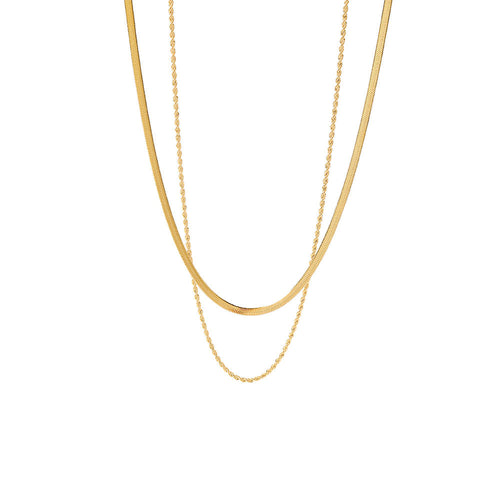 Layered gold herringbone and rope necklaces on a white background. Stainless steel jewelry, gold simple chains