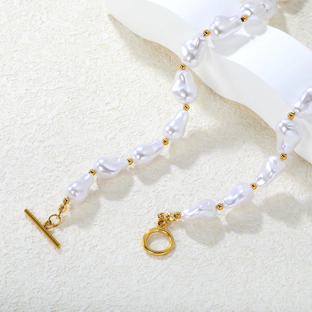 Pearl necklace with gold OT toggle on a textured white surface. chunky pearl necklace gold, toggle clasp necklace, statement pearl necklace