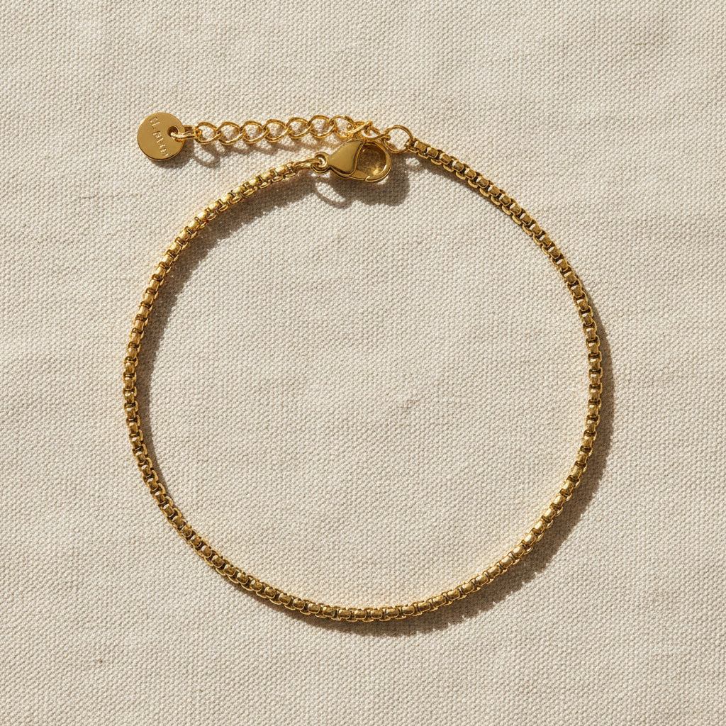 Gold box chain bracelet on a white background