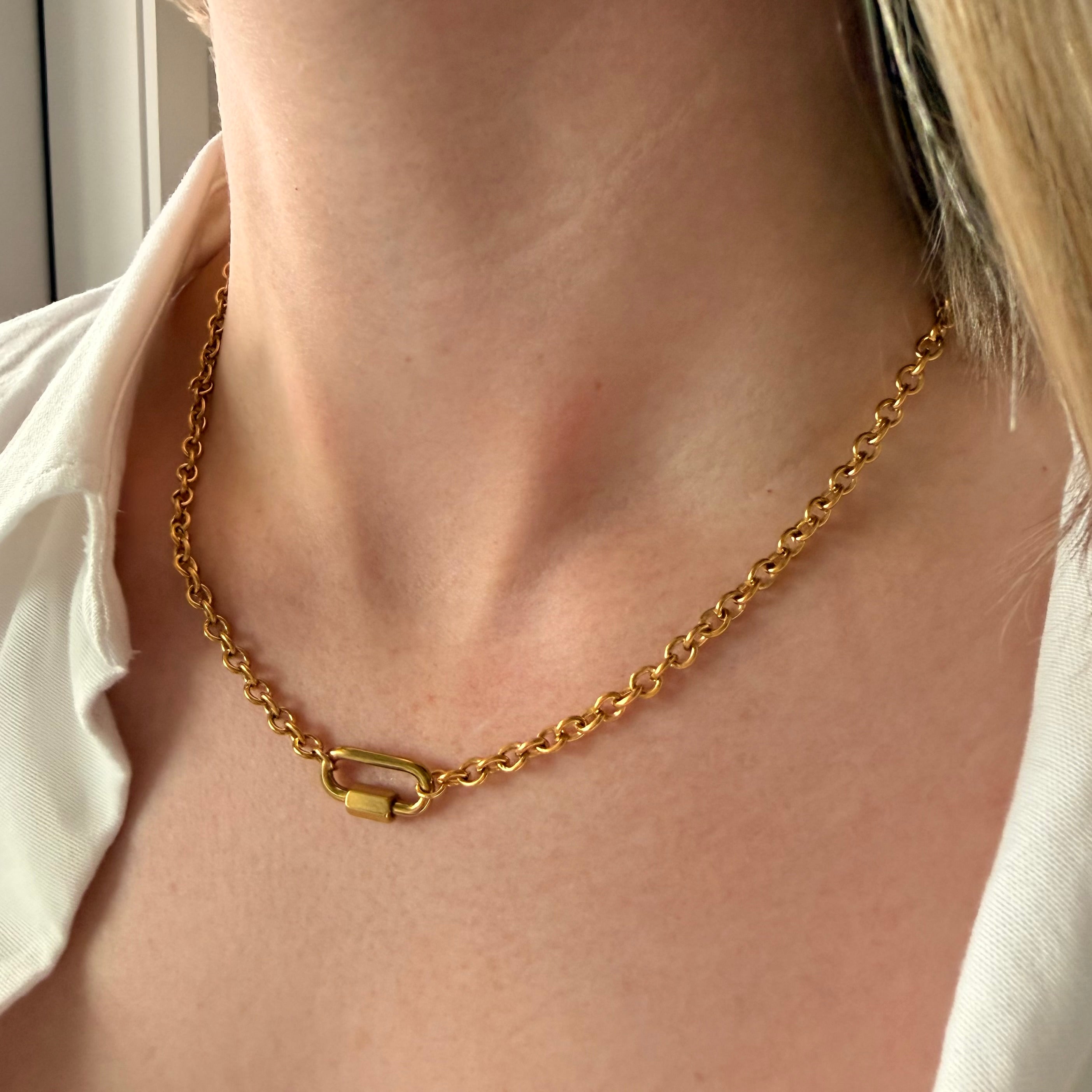 Gold chain necklace with carabiner lock on a white background. paperclip chain necklace gold, carabiner lock necklace, gold link necklace