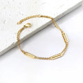 Gold double chain bracelet on a white stone surface. double chain bracelet gold, layered chain bracelet, oblong link bracelet