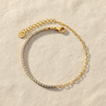 Gold bracelet with zirconia diamond stones on a white background