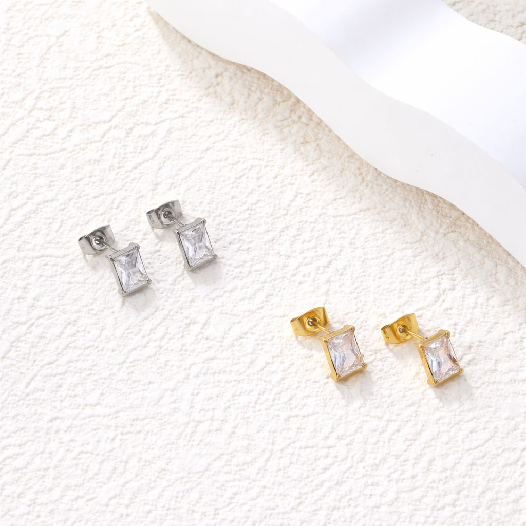 Gold and silver square zirconia stud earrings on a textured white surface. rectangular zirconia stud earrings gold, crystal stud earrings, minimalist gold earrings