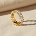 Gold ring with white zirconia gemstones on a white background
