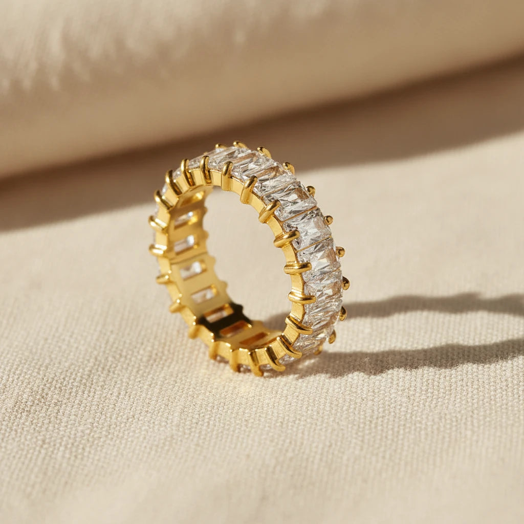 Gold ring with white zirconia gemstones on a white background