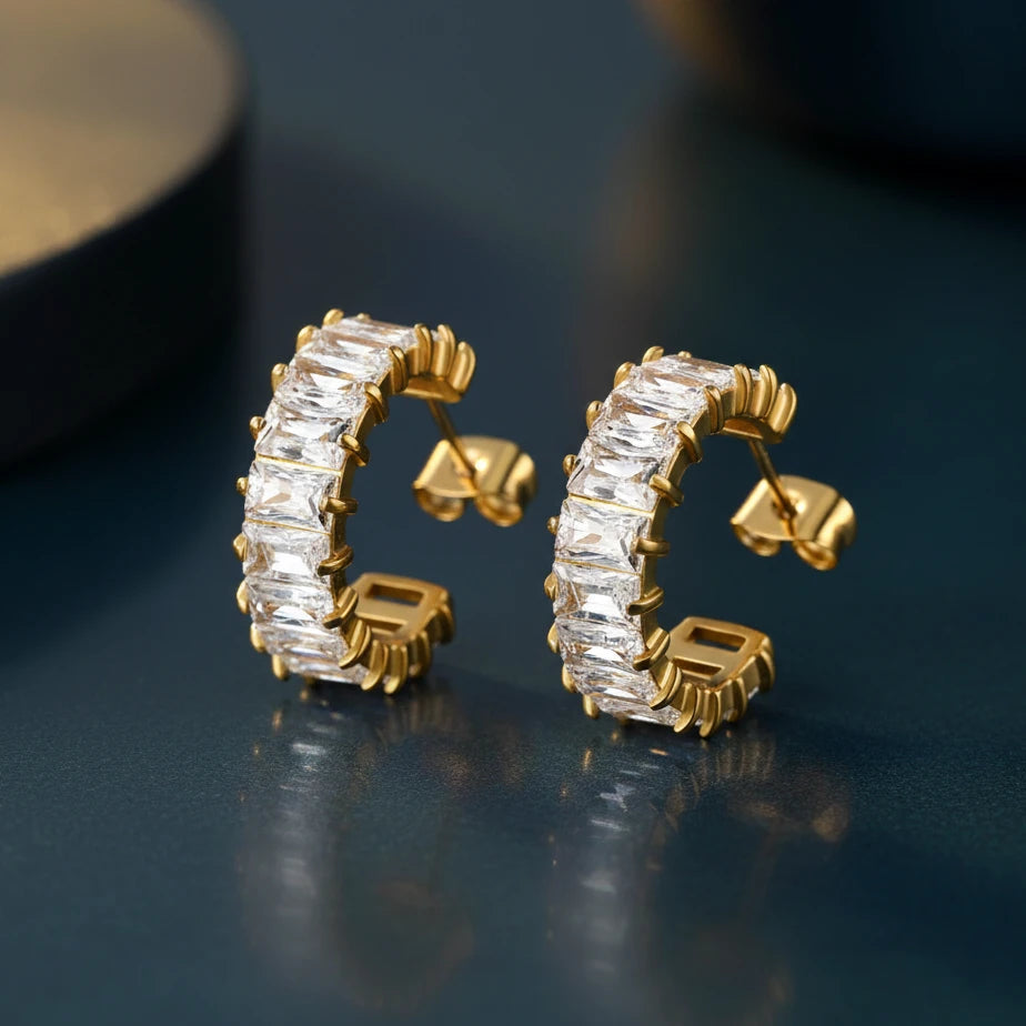 Gold half hoop earrings with zirconia gemstones on a white background. Zirconia half hoop earrings, pavé gold earrings, gold half hoop earrings