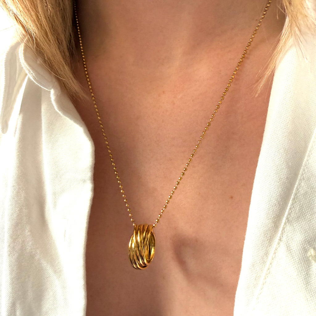 Gold necklace with a multi-circle pendant on a woman wearing a white shirt. Multi circle necklace gold, layered circle pendant necklace, minimalist gold necklace