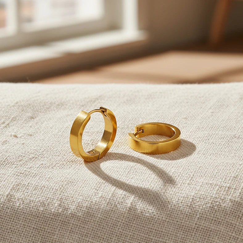 Gold hoop earrings on a light background