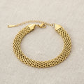 Gold mesh chain bracelet on a white background. 