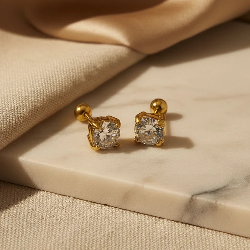 Gold stud zirconia earrings with zirconia gemstones on a white background. round zirconia stud earrings, gold stud earrings, minimalist stud earrings
