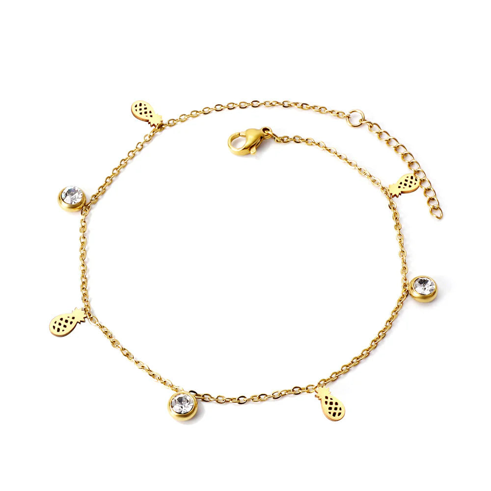 Gold anklet with pineapple and round zirconia charm on a white background