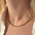 Gold necklace on a woman's neck. gold rope chain necklace, twisted chain necklace, textured gold necklace