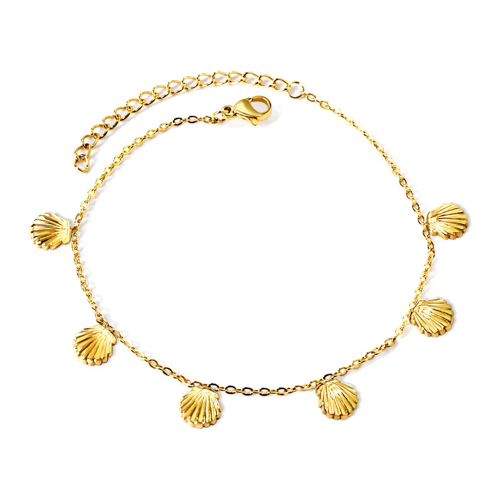 Gold anklet with seashell-shaped charms on a white background. shell charm anklet gold, beach anklet, ocean inspired anklet