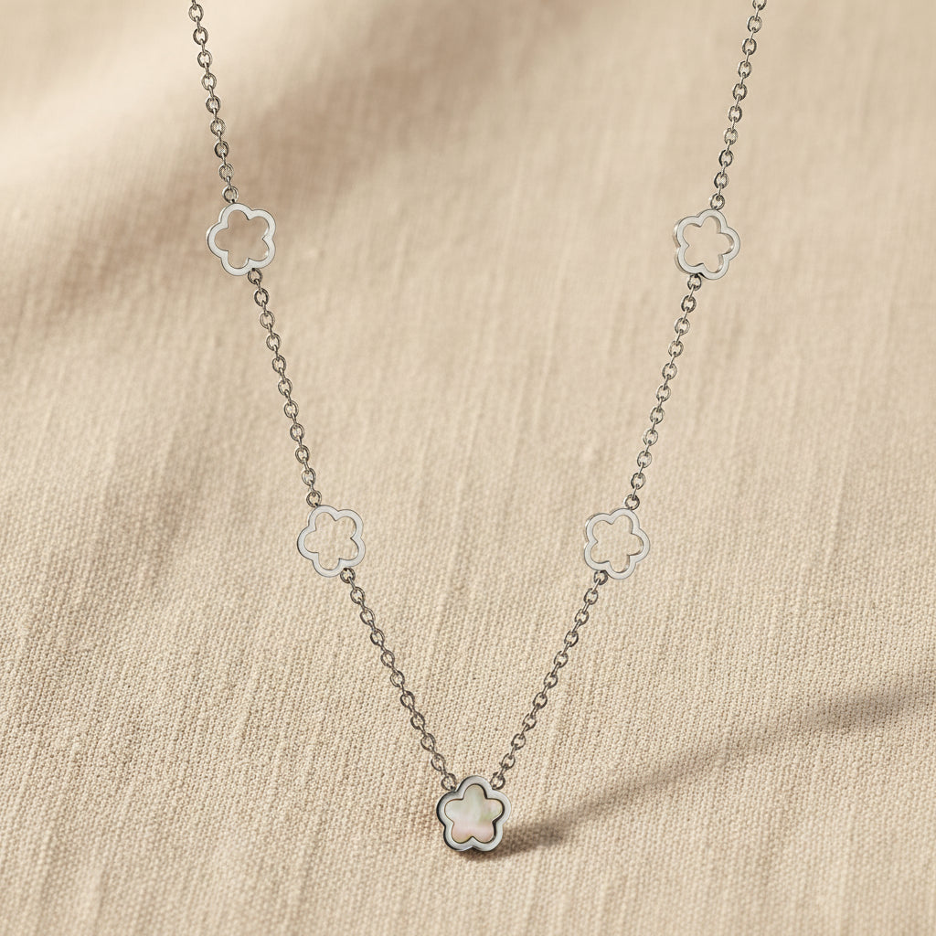 Silver necklace with cherry blossom shaped pendants on a white background