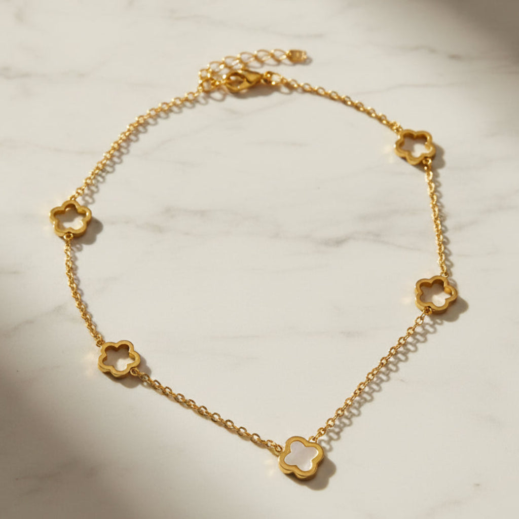 Gold necklace with cherry blossom pendants on a white background