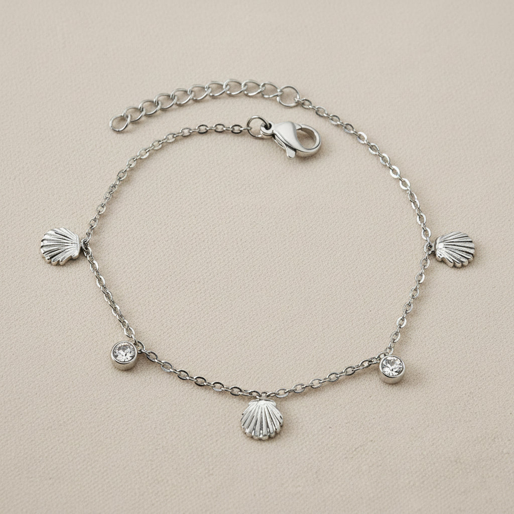 Silver bracelet with shell and zirconia charms on a white background