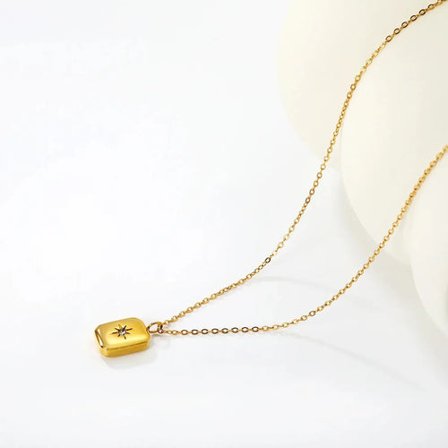 Gold necklace with a square pendant and zirconia start on a white background