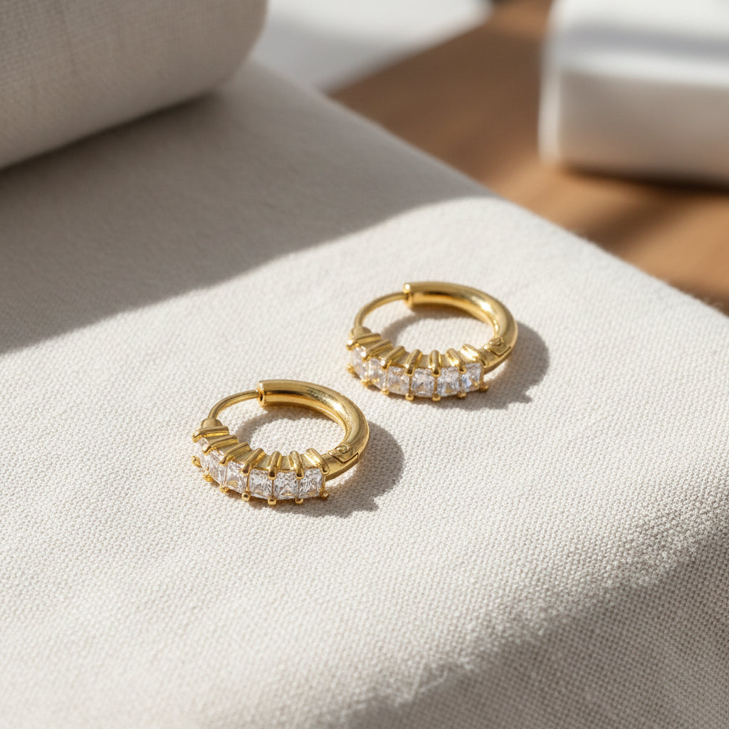 Gold hoop earrings with cubic zirconia diamonds on a white background. gold huggie earrings, zirconia huggies, everyday gold earrings
