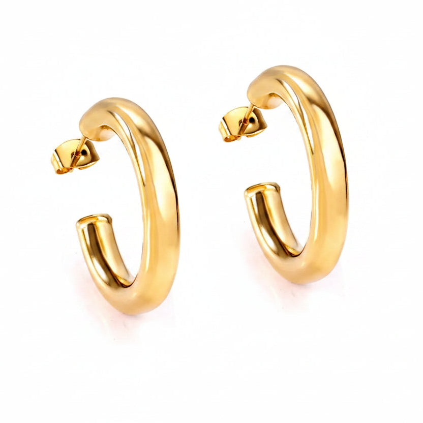 Gold half hoop earrings on a white background 