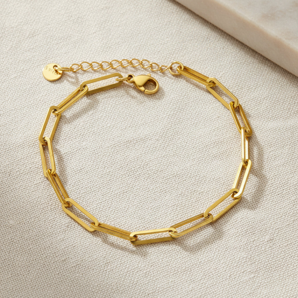 Gold paperclip bracelet on a white background