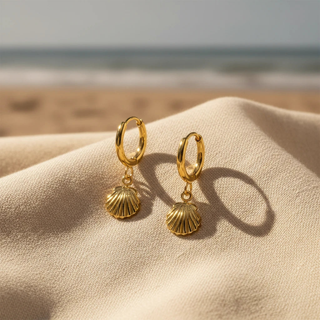 Gold hoop earrings with shell charms on a white background