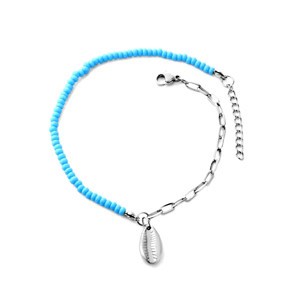 Anklet with conch shell charm and blue beads and silver chain on a white background. Beach jewelry, stainless steel jewelry