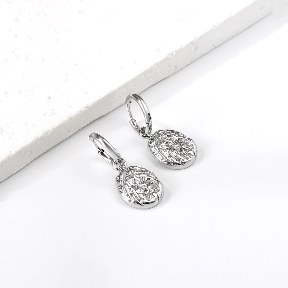 Pair of silver textured drop earrings on a white surface. silver drop earrings, vintage style earrings, statement drop earrings