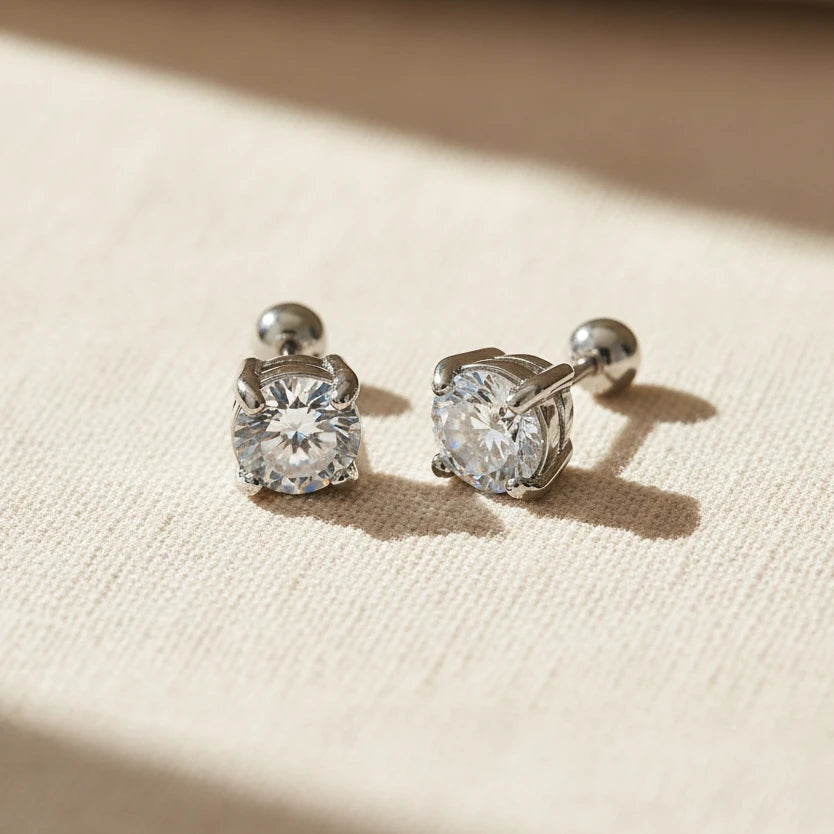 Pair of silver stud earrings with zirconia gemstones on a white background. round zirconia stud earrings, gold stud earrings, minimalist stud earrings