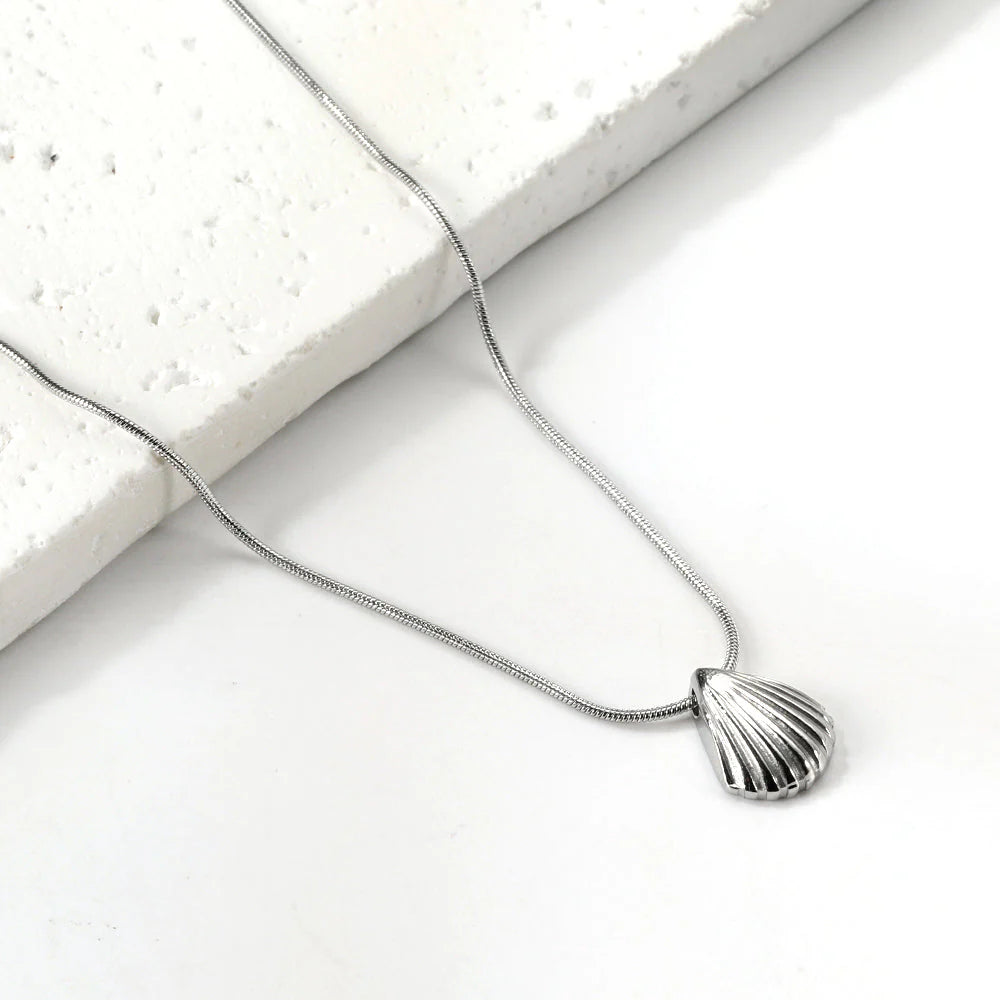 Silver shell pendant necklace on a white background. Ocean inspired jewelry. Beach necklace.