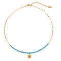 Necklace with turquoise beads and a gold sun  pendant on a white background