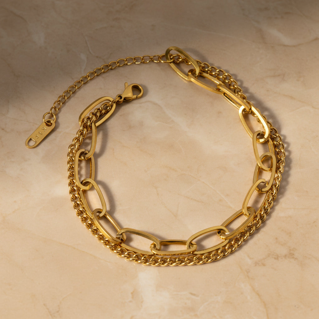 Gold double chain bracelet on a white background