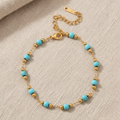 Gold bracelet with turquoise beads on a white background. turquoise bead bracelet gold, gold chain bracelet, blue stone bracelet